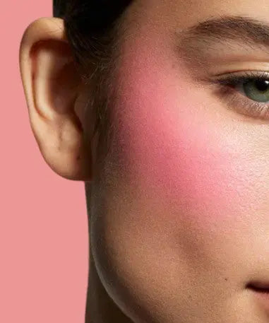 Coral powder blush applied on model cheek | SIX BEAUTY